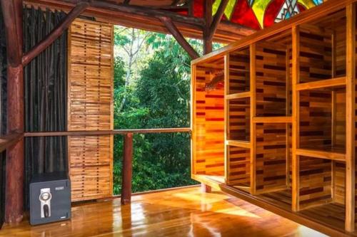 a room with a large window in a wooden building at Surfers´bohemian dream overlooking the point break in Cabo Matapalo