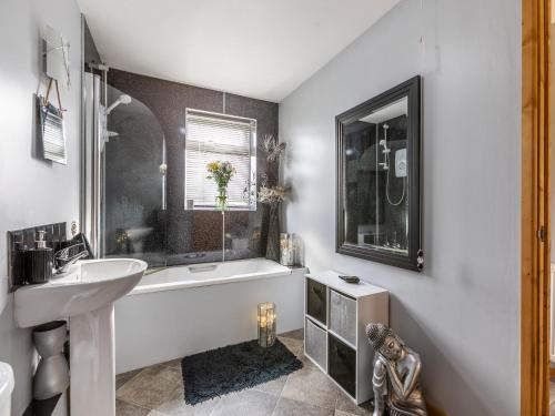 西蒙茲亞特的住宿－Flyby Cottage，浴室配有白色浴缸、盥洗盆和浴缸。