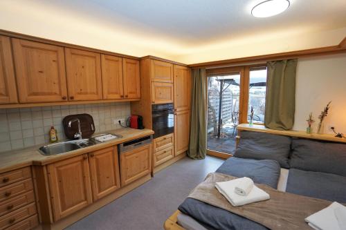a kitchen with wooden cabinets and a couch in it at Apart Lisa in Huben