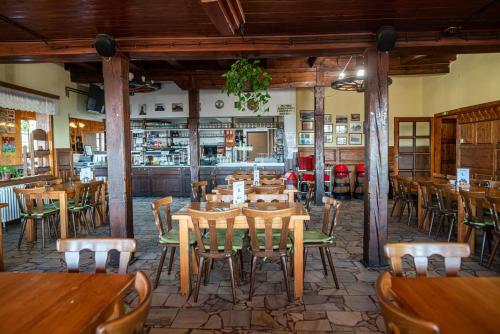 Horský hotel Paprsek في ستاريه ميستو: مطعم بطاولات وكراسي خشبية في الغرفة