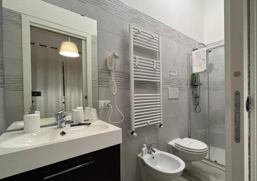 a white bathroom with a sink and a toilet at La Maison in Acquaviva delle Fonti