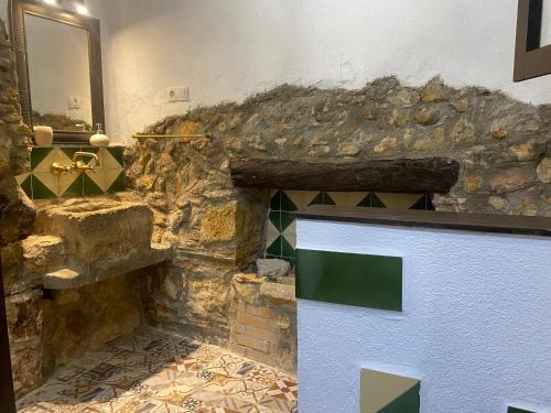 Baño de piedra con pared de piedra y puerta en Cal Castlà, 
