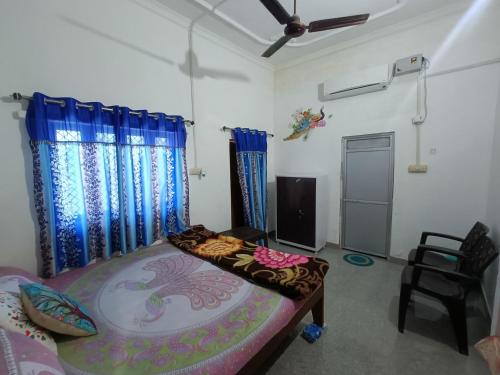 Habitación con cama, TV y cortinas. en Khajuraho Homestay en Khajurāho