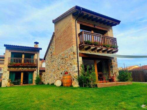 a brick house with a balcony and a yard at La Galiana loft nature in Casarejos
