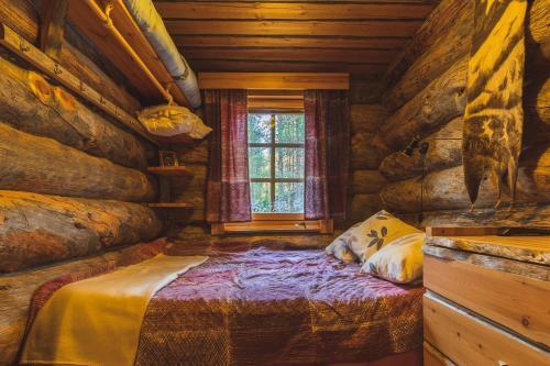 a bedroom with a bed in a log cabin at Hellevi in Levi