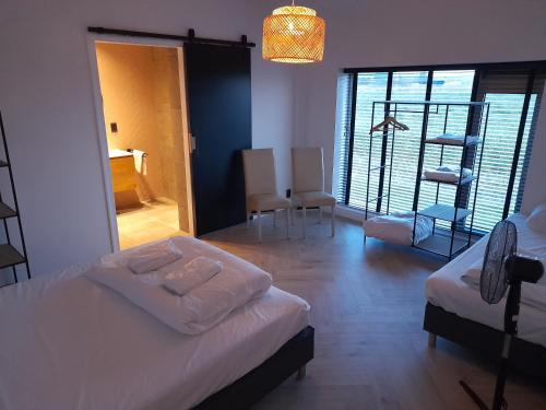 een slaapkamer met 2 bedden en een kamer met een ladder bij villa the Tulip JULIA in Julianadorp