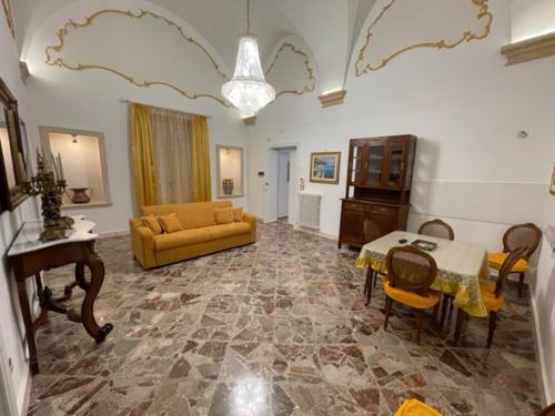 sala de estar con sofá amarillo y mesa en B&B DAMAPAGA Palazzo GRAPPA, en Galatina