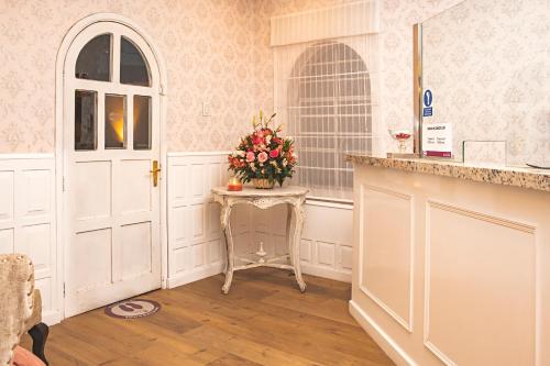 a kitchen with a table with a vase of flowers on it at Hotel Hanan Deluxe in Arequipa