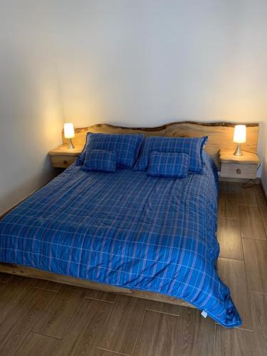 a bed with a blue plaid blanket and two night stands at Maravilloso chalet en la zona colonial (303) in Zipaquirá