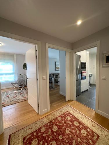 a living room with a door open to a kitchen at A estrenar amplio con piscina y parking in Getxo