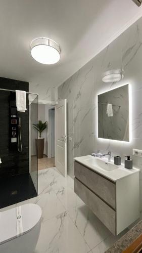 a white bathroom with a sink and a mirror at AMERICAN GARDEN HOUSE in Nettuno
