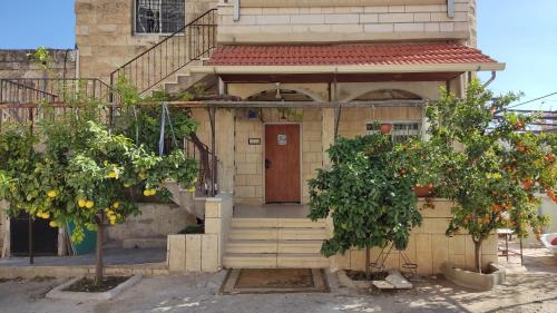 a house with a wooden door and two trees at Issa's House in Beit Sahour