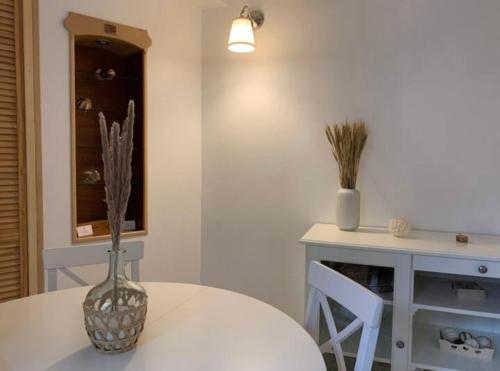 uma mesa de jantar com um vaso em cima em Aux Vieilles Murailles • Charmante maison & cour em Morlaix