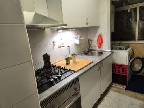 a small kitchen with a stove and a sink at Habitación Elegante in Barcelona
