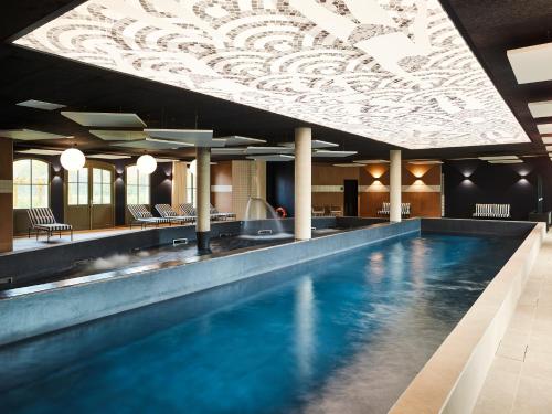 basen w hotelu z sufitem w obiekcie TRIBE Hôtel Le Touquet w mieście Le Touquet-Paris-Plage