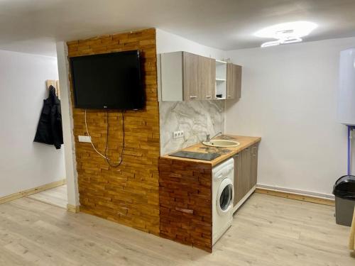 una cocina con lavadora y secadora junto a una pared de ladrillo en Apartament C&C, en Voineasa