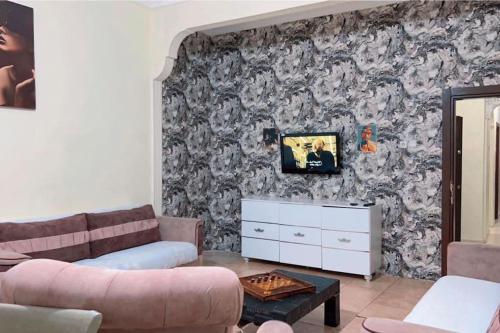 a living room with a couch and a tv on a wall at Şişli harbiye kat iki in Istanbul