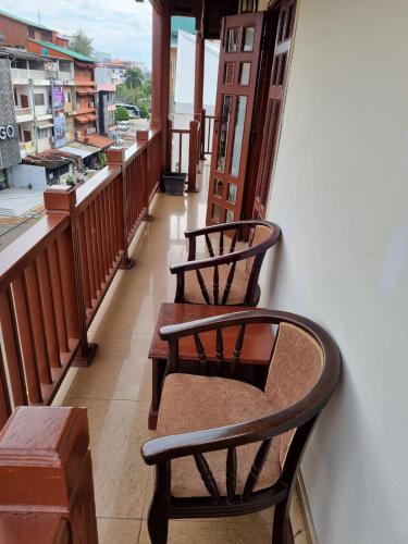 two chairs on a balcony with a view of a city at khampiane hotel in Ban Nongdouang