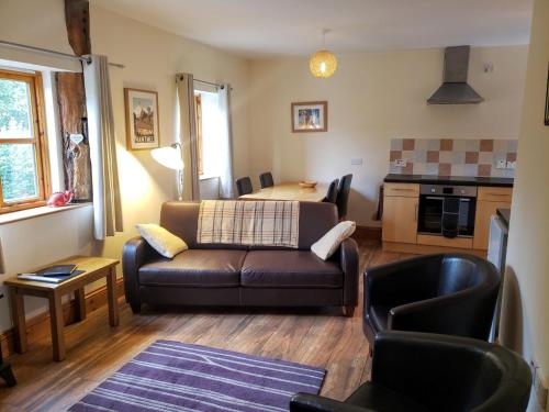 a living room with a couch and a table at Seven Stars- hot tub & garden with fabulous views. in Llandrindod Wells