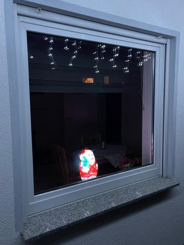 a stuffed animal sitting in a window with christmas lights at Villa Hardegsen in Hardegsen