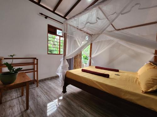 ein Schlafzimmer mit einem Bett mit Moskitonetz in der Unterkunft King CoCo House in Dikwella