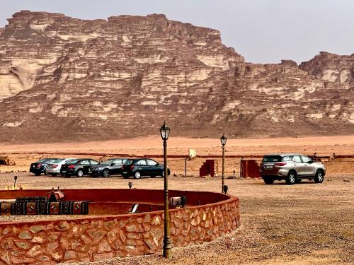 a group of cars parked in front of a mountain at Shakria Bedouin Life Camp in Wadi Rum