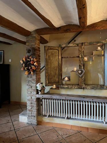 a room with a wall with a window and a vase of flowers at Les Vinyes Alojamiento Rural Boutique & SPA in Vilardida