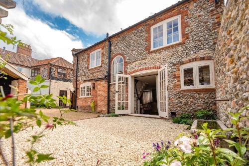 an exterior view of a brick house with a driveway at Number 27 by Big Skies Cottages in Holt