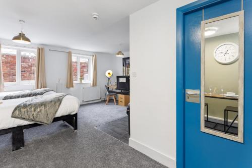 a bedroom with a bed and a clock on the wall at City Centre Studio 3 with Kitchenette, Free Wifi and Smart TV with Netflix by Yoko Property in Middlesbrough