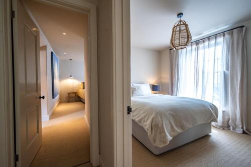 a bedroom with a white bed and a window at Number 27 by Big Skies Cottages in Holt