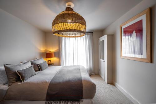 a bedroom with a large bed and a chandelier at Number 27 by Big Skies Cottages in Holt