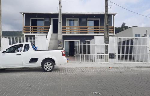 un camión blanco estacionado frente a una casa en CK - APTO TIPO LOFT Individual ar, wifi, vaga, cozinha-, en Itapema