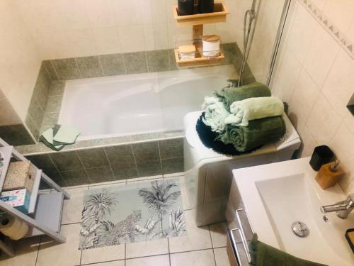 een badkamer met een bad en een wastafel bij Le camélia in Tallard