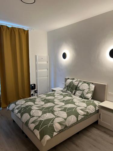 a bedroom with a bed with a green and white comforter at Riverbank Guest House in Namur