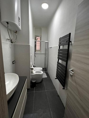 a bathroom with two sinks and a toilet in it at A.P. Appartamento o camera in Corsico