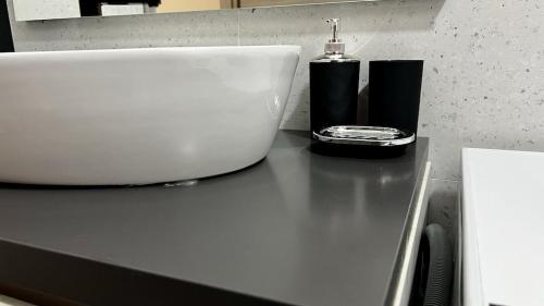 a black counter top with a soap dispenser on it at A.P. Appartamento o camera in Corsico