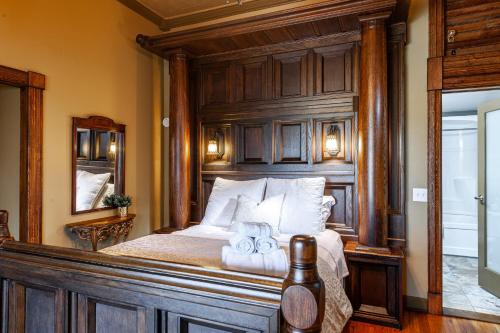 um quarto com uma cama e uma cabeceira em madeira em Henry House - Patio Suite - An Arrivals Stay em Stratford
