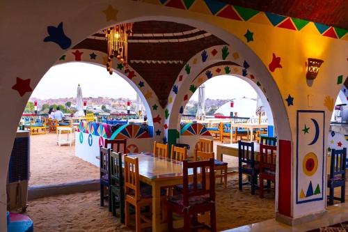 a restaurant with arches and tables and chairs at Onaty Ka Guest House in Aswan