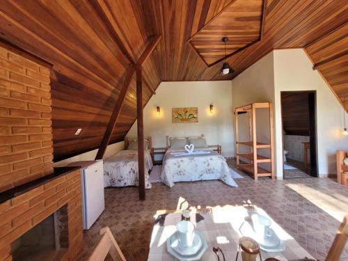 a bedroom with a bed in a room with wooden ceilings at Villa das Palmeiras Chalés & Camping in São Bento do Sapucaí