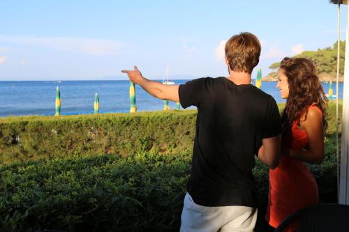 a man and a woman looking at the ocean at Residence Le Acacie in Capoliveri