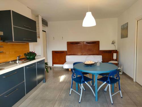 una cucina con tavolo e sedie blu e un letto di ,,,a casa di Martina a Mestre