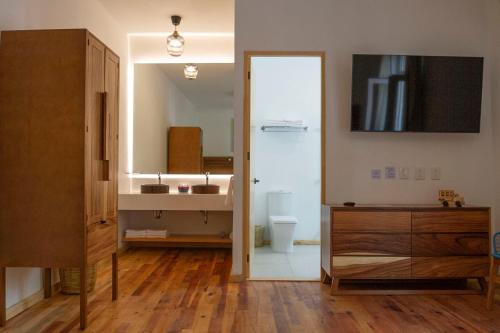 La salle de bains est pourvue d'un lavabo, de toilettes et d'un miroir. dans l'établissement NaNa Vida CDMX, à Mexico