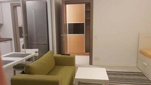uma sala de estar com um sofá verde e uma mesa em 21 Residence Apartments em Bucareste