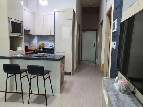 a kitchen with a counter and two stools in a room at Cozy House in Daegu
