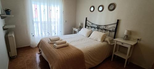 1 dormitorio con 1 cama grande y 2 toallas. en Casa Rural Dompani, Ahigal, en Ahigal