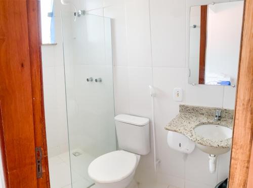 a bathroom with a toilet and a sink at Pousada Suítes do Atlântico in Ilhéus