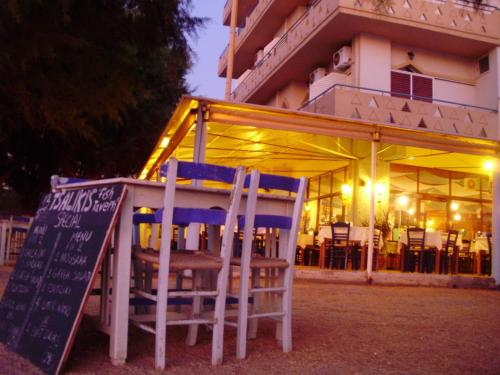 a restaurant with chairs and a sign in front of it at Melani Apartments in Chania