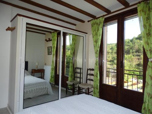 a bedroom with a bed and a large mirror at Métairie de Lamourade - Un écrin de nature sereine in Saint-Ferriol