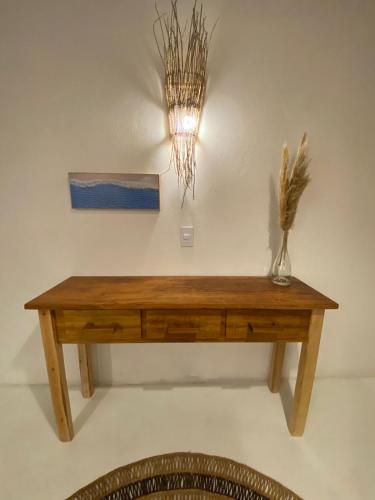 a wooden table on a wall with a vase on it at Casa Nature Atins in Atins