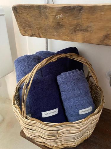 kosz z fioletowymi ręcznikami na półce w obiekcie Casa Nature Atins w mieście Atins